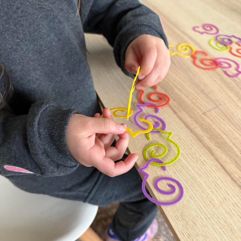 Child plays with Duck-links bookmarks for fine motor skill development