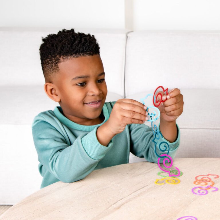 5 year old boy plays with Duck-links linking them together to improve fine motor skills