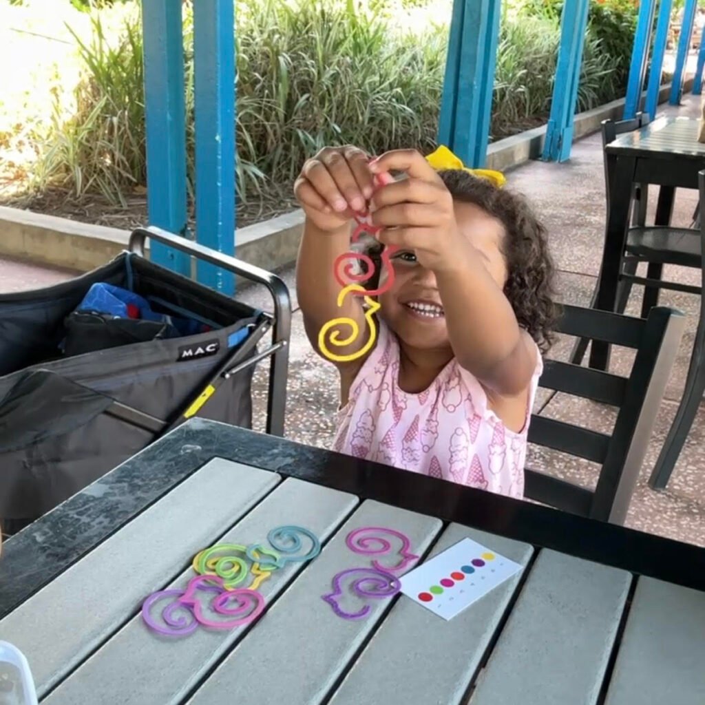 3-4 year old girl plays with her duck-links any where game set while on a family trip