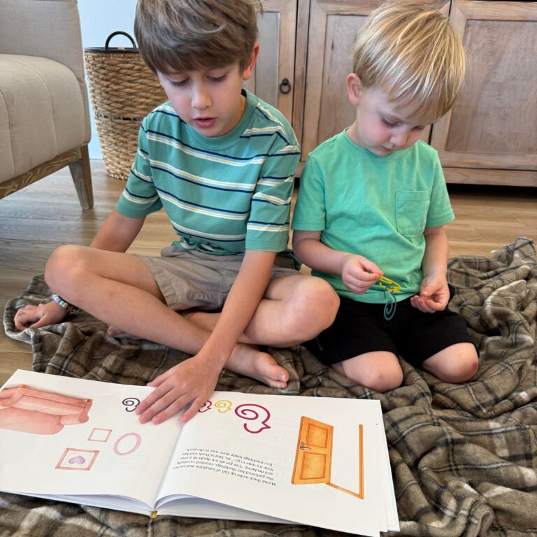 An 8 year old boy reads ALL MY DUCKS IN A ROW children's picture book to his 3 year old brother as his brother plays with Duck-links for fine motor skill development