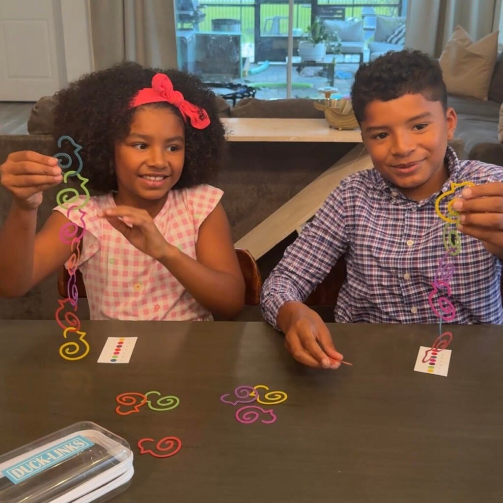 Sister and brother playing Duck-links Anywhere Game Set smiling, laughing and building family connection.